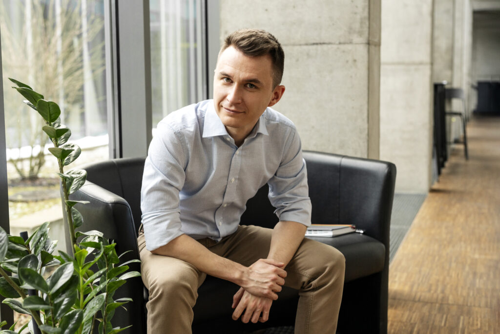 mężczyzna w niebieskiej koszuli siedzący na czarnej kanapie