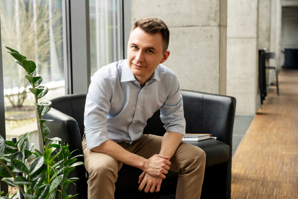 mężczyzna w niebieskiej koszuli siedzący na czarnej kanapie