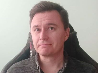 uśmiechnięty mężczyzna w szarej bluzie