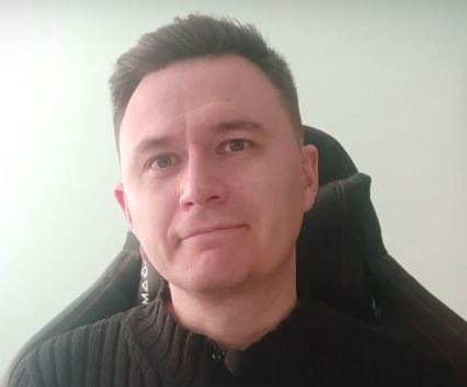 uśmiechnięty mężczyzna w czarnym swetrze